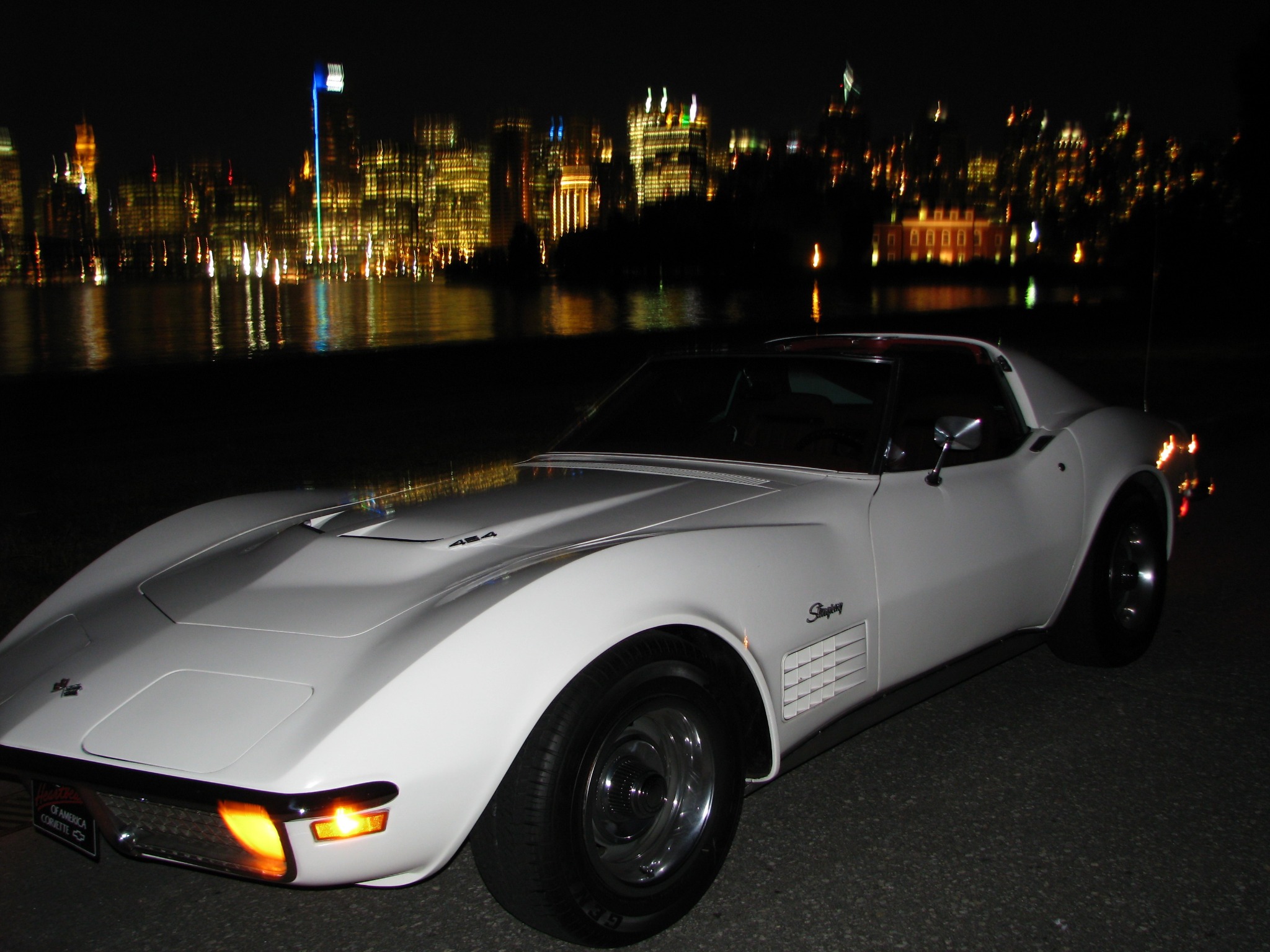 White Chevrolet Corvette photographed at night beside the waterfront