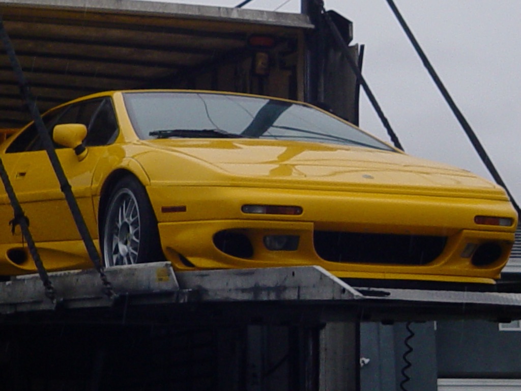 Yellow 2002 Lotus Esprit V8 on the transporter's unloading platform